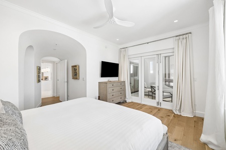 Drift off in this bright, serene bedroom with crisp linens, warm wood floors, and your own private balcony just steps away—perfect for morning coffee or evening stargazing.