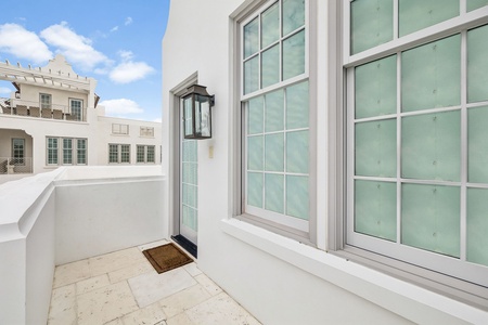 Step onto your private balcony, where soft tile underfoot and classic lantern light create a serene escape framed by elegant frosted windows.