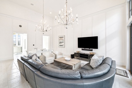 Sink into luxurious leather seating while sparkling chandeliers cast warm light across your elegant living space.
