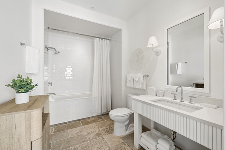 Step into your bright, modern bathroom with classic white tile, a soothing tub-shower combo, and fresh towels waiting for you. The dual-sink vanity offers plenty of space to unwind and refresh.