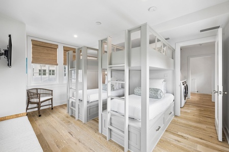 Gather your crew in this charming bunk room with custom-built sleeping quarters and warm wood floors that invite laughter and memories together.