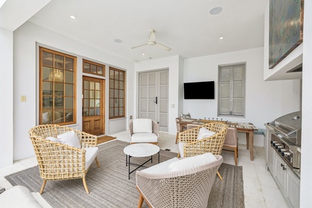 Gather with friends in this airy indoor-outdoor space, perfect for relaxing or sharing meals. Comfortable woven seating, a sleek dining table, and modern entertainment create your ideal retreat.