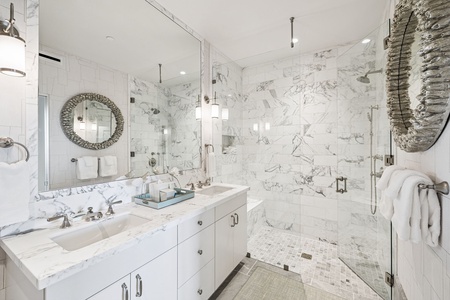 Unwind in your luxurious marble bathroom, featuring a stunning walk-in shower and elegant double vanity for ultimate relaxation.