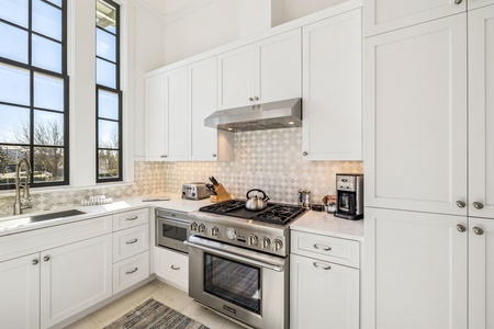 Your spacious kitchen features gleaming white cabinets, professional-grade appliances, and elegant backsplash—perfect for creating memorable meals together.
