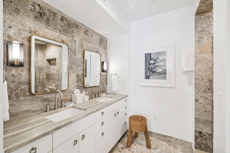 Indulge in your elegant master bathroom featuring stunning marble surfaces, dual vanities, and warm brass accents for a truly luxurious experience.
