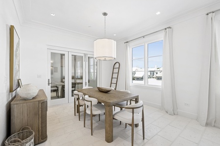 Gather around the elegant dining table with natural light streaming through large windows, inviting you to share memorable meals in this beautifully designed space.