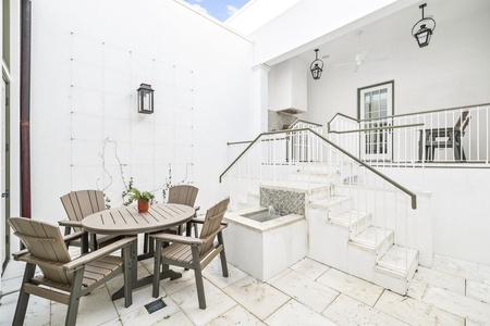 Your private courtyard offers peaceful outdoor dining with a custom fire feature and elegant staircase access.