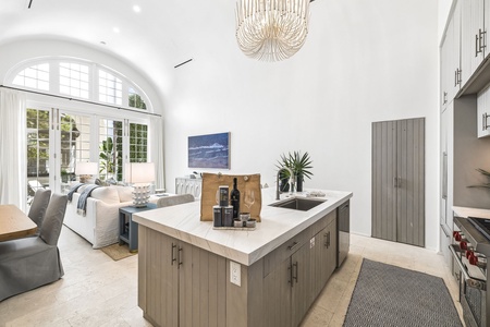Step into a sunlit, open-concept living space where soaring ceilings and elegant details create a sense of grandeur. The gourmet kitchen invites you to gather around the island, while the living area beckons for relaxed evenings.
