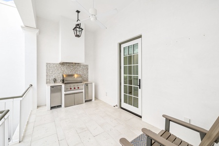 Your private covered patio features a premium outdoor kitchen with stainless steel grill and mosaic tile backsplash for memorable al fresco dining.