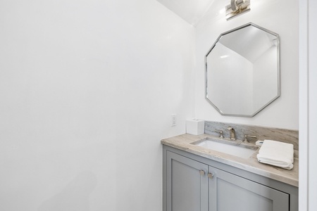 Freshen up in your private bathroom with elegant marble countertops, modern fixtures, and plush towels. The geometric mirror and soft lighting add a contemporary touch to your retreat.