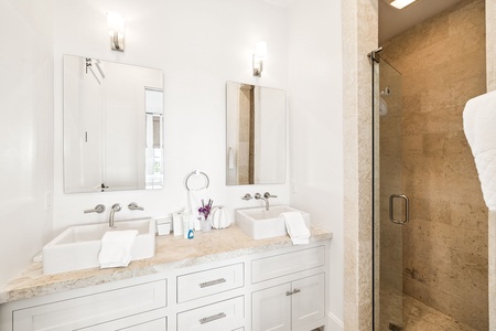 Your luxurious bathroom features dual vessel sinks, elegant marble countertops, and a spacious walk-in shower perfect for refreshing mornings.
