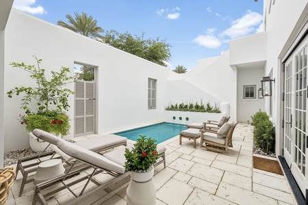 Your private courtyard oasis awaits with a sparkling pool, plush loungers, and lush greenery—a serene escape for sunny afternoons and warm evenings under the palms.