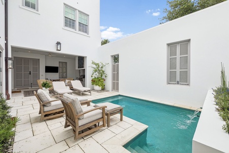 This modern outdoor oasis features a sparkling private pool surrounded by comfortable lounge seating, perfect for soaking up the sun or unwinding after exploring nearby attractions.