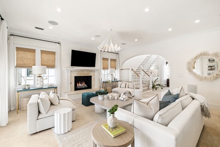 Sink into plush white sofas by your cozy fireplace, where elegant coastal touches create the perfect space to unwind after your adventures.