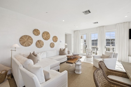Sink into plush white furnishings in your elegant living space, where natural textures and city views create the perfect backdrop for relaxation.