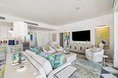 Relax in your stylish open-concept living area with vibrant art, plush seating, and modern amenities perfectly designed for comfort.