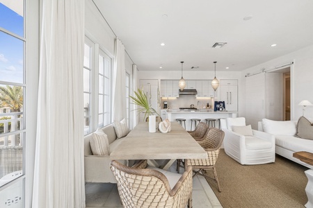 Relax in this bright, airy living space where natural light floods through floor-to-ceiling windows, creating the perfect atmosphere for memorable meals and conversations.