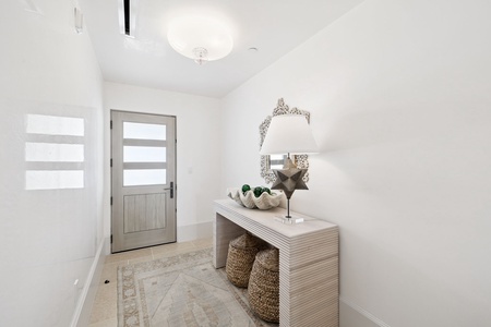 Step into your elegant entryway, where natural light filters through frosted glass and thoughtful décor creates an immediate sense of sophistication and warmth.