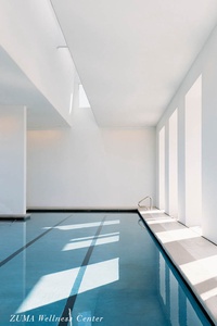 Slip into the serene indoor pool where natural light dances across crystal-clear waters, creating your perfect retreat.