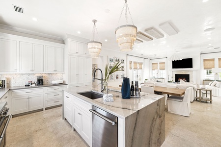 You'll love cooking in this stunning gourmet kitchen featuring marble countertops, elegant chandeliers, and seamless flow into the living area.