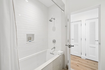 Refresh in this all-white bathroom with a shower-tub combo, subway-tile surround, and a convenient built-in niche for your essentials.