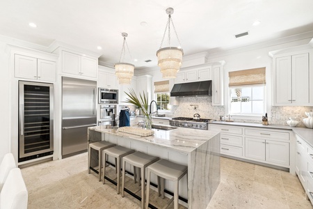 Your dream chef's kitchen awaits with stunning marble island, professional appliances, and elegant lighting.