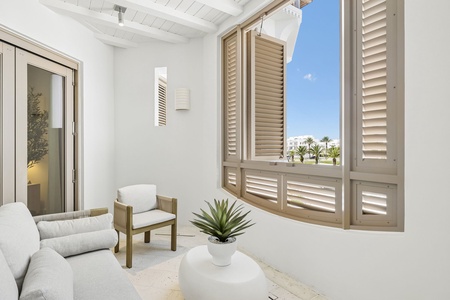 Step into your serene private lounge where coastal breezes and palm tree views invite you to unwind in peaceful comfort.