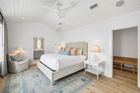 Step into your serene retreat with a plush bed dressed in crisp linens and colorful accent pillows. A cozy reading chair awaits by the window, while soft lighting and soaring ceilings create your peaceful escape.