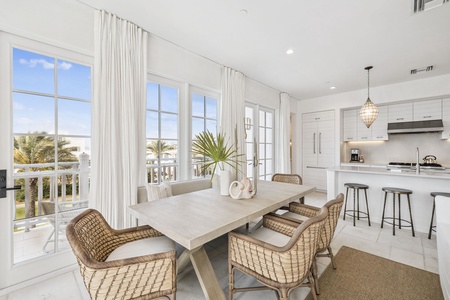 Gather around this elegant dining table where natural light pours through expansive windows, creating the perfect backdrop for memorable meals together.