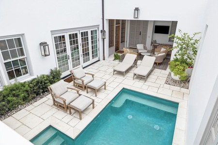 This serene inner courtyard features a sparkling pool and luxurious loungers—an intimate oasis perfect for relaxation and enjoying the Florida sun in complete privacy.