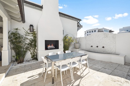 Enjoy al fresco dining in this stunning courtyard oasis, complete with a modern fireplace and lush greenery creating your perfect outdoor retreat.