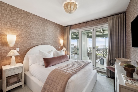 Sink into luxurious linens and wake to your private balcony views in this elegantly designed bedroom sanctuary.