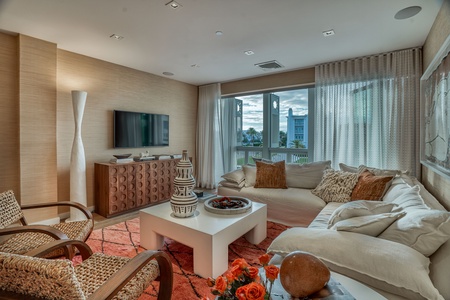 Sink into the plush sectional and take in your pool view from this beautifully appointed living room. Natural textures, warm wood tones, and thoughtful design create a welcoming retreat for relaxation.
