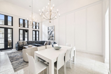 Gather around your elegant dining table while soft chandelier light creates the perfect ambiance for memorable meals in your sophisticated living space.