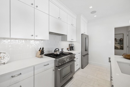 Whip up your favorite meals in this bright, fully equipped kitchen with sleek stainless appliances, abundant counter space, and crisp white cabinetry that make cooking feel effortless.