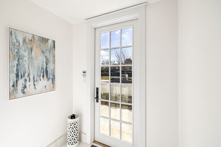 Step through elegant French doors onto your private patio, where crisp white walls showcase beautiful art and peaceful garden views await.