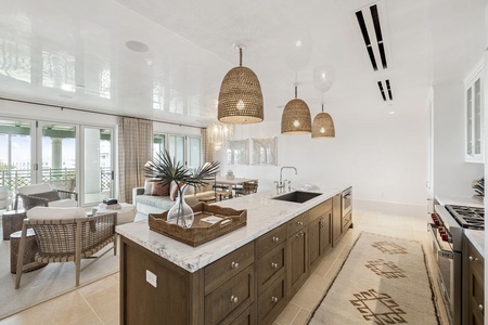You'll love cooking in this stunning kitchen with marble countertops, woven pendant lights, and views of your private balcony terrace.