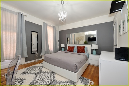 Your stylish sanctuary features a plush bed, elegant chandelier, and modern amenities for perfect relaxation.