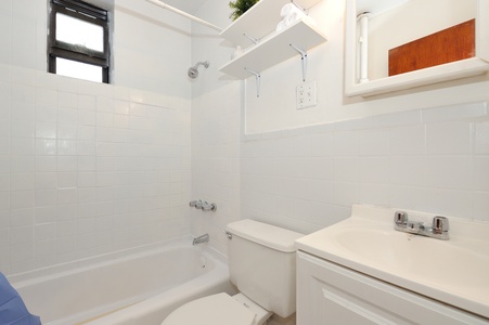 Your pristine white bathroom offers a relaxing soaking tub and modern fixtures for your comfort.