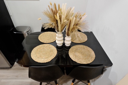 Your stylish dining space awaits with thoughtful touches—woven placemats and dried pampas grass create a warm, natural ambiance for memorable meals.