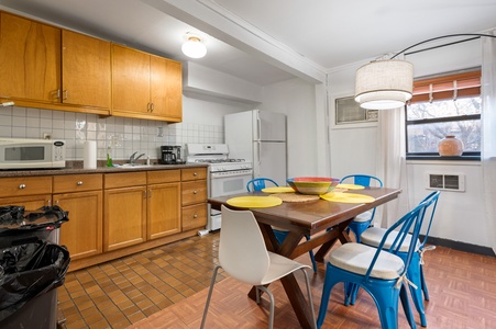 Your spacious kitchen invites you to cook together, with warm wood cabinets, modern appliances, and a welcoming dining area.
