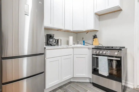 Your fully equipped kitchen features sleek stainless steel appliances and crisp white cabinets, perfect for preparing meals during your stay.