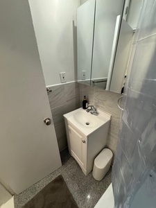 Your private bathroom features sleek marble-style tiles and a modern vanity, creating a clean, spa-like retreat for your stay.