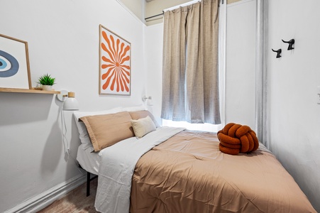 Rest easy in your cozy bedroom featuring warm earth tones, vibrant artwork, and thoughtful touches for a perfect night's sleep.