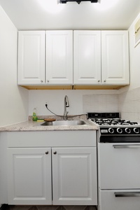 Your compact kitchen features everything you need to prepare meals, with crisp white cabinetry, granite countertops, and full-size appliances.