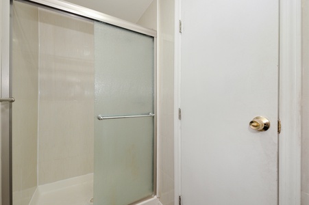 Your private bathroom features a spacious walk-in shower with frosted glass doors, offering comfort and privacy during your stay.