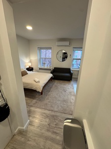 Unwind in your serene bedroom where natural light streams through large windows, creating a peaceful retreat with modern comfort.