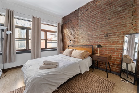 Your industrial-chic bedroom blends exposed brick walls with modern comfort, creating the perfect urban retreat for restful nights.