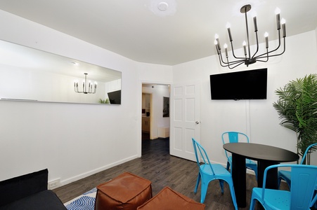 Relax in your bright living space with modern dining table, cozy seating, and entertainment center for memorable evenings together.