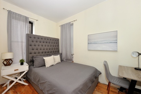 Sink into this luxurious tufted headboard bed with soft linens. Your peaceful retreat features natural light and stylish furnishings for ultimate comfort.